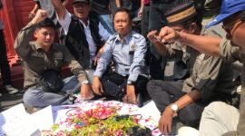 Insan media Nganjuk sedang melakukan aksi tabur bunga di atas kartu pers mereka di pintu gerbang gedung DPRD Nganjuk.(Poto:ifakta.co /may)