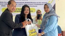 Ketua Kelompok C3 KKN Universitas Budi Luhur didampingi dosen pembimbingnya saat bagikan merchandise usai sosialisasi penggunan Marketplace dan E-commerce. (Foto: Ifakta.co)