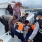 Momen Briptu M. Ilham membantu seorang Lansia yang kesulitan turun dari kapal di Dermaga Kali Adem, Pelabuhan Muara Angke, Kamis (26/12/2024). 