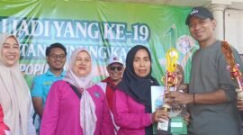 Istri kepala Desa Kedung H.Saadullah terima piala juara pertama dari Camat Kurnia usai gerak jalan sehat (foto:ifakta.co/Alex)