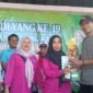Istri kepala Desa Kedung H.Saadullah terima piala juara pertama dari Camat Kurnia usai gerak jalan sehat (foto:ifakta.co/Alex)