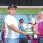 Deni sekcam gunung Kaler berikan piala dan hadiah  kepada istri kepala desa Rancagede dalam meriah juara pertama lomba paduan suara (foto:ifakta.co/Alex)